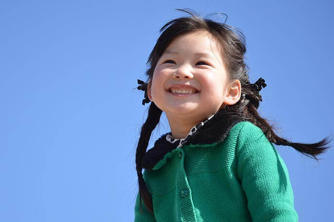 子どもの笑顔と青空